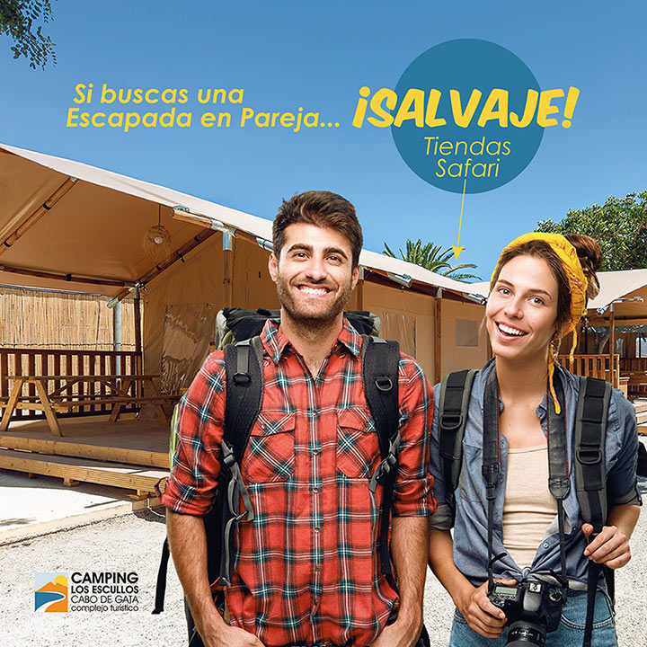 Pareja joven, hombre y mujer, frente a una tienda safari con el texto "Si buscas una escapada en pareja... ¡salvaje!