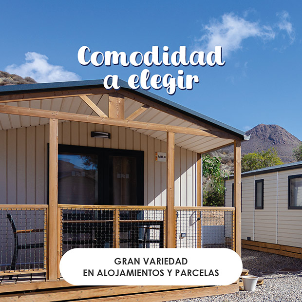 Comodidad a elegir - Gran variedad en alojamientos y parcelas Entrada exterior a un mobilhome del camping, con un pequeño y acogedor porche con una mesa y sillas
